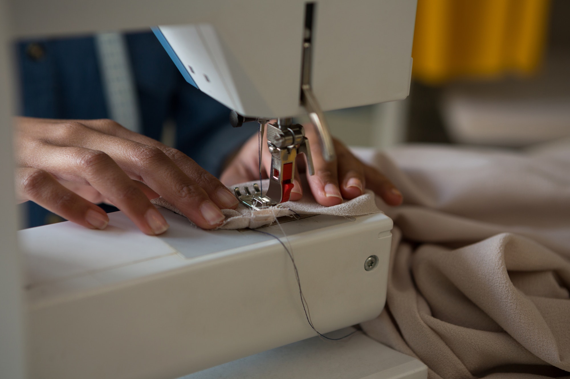 Fashion designer stitching cloth in sewing machine